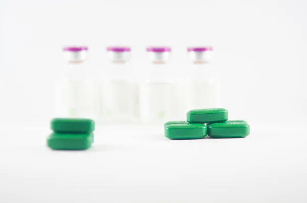 Зеленая таблетка на фоне медицины — стоковое фото