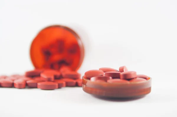 Коричневые таблетки на фоне бутылки с лекарством — стоковое фото