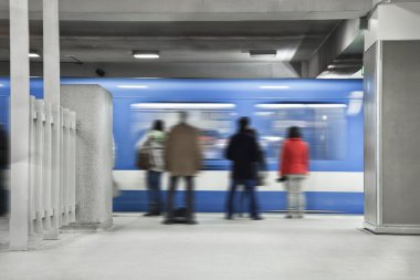 Metroda bekliyor. Tren geçerken.