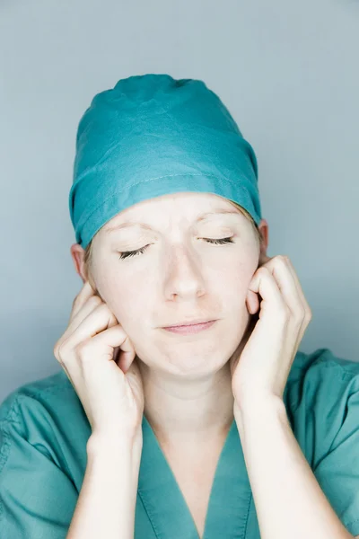 Die Krankenschwester schließt die Ohren Stockbild