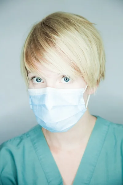 Arzt mit Maske schaut Patient an Stockbild
