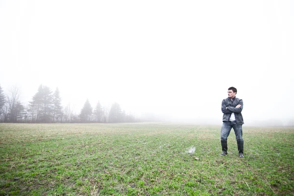 Young man In the foggy field — Stok fotoğraf