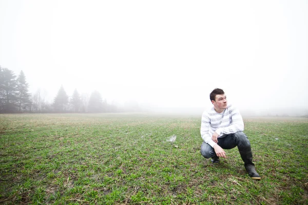 Junger Mann im nebligen Feld — Stockfoto