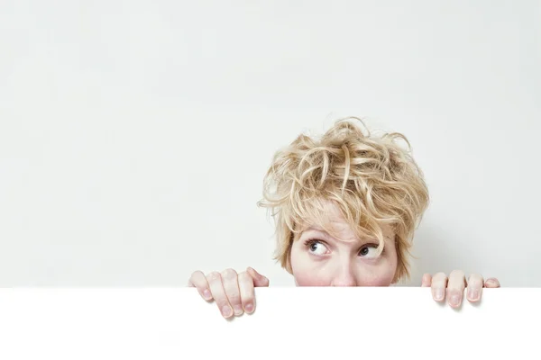 Roztomilá blondýnka drží bílou tabuli — Stock fotografie