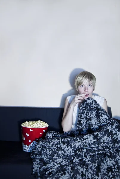 Flicka lyssna till skräck eller spänning film ensam. — Stockfoto