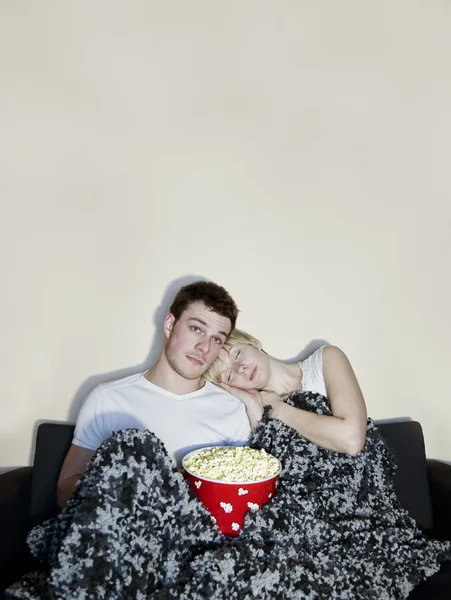 텔레비전을 시청 하 고 팝콘을 먹는 젊은 부부 — 스톡 사진