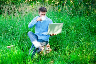 genç adam açık havada Kupası ve dizüstü