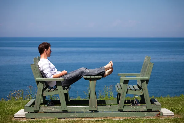 Young man sitting on the beach — Stock Photo, Image