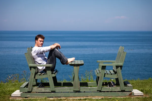 해변에 앉아 있는 젊은이 — 스톡 사진
