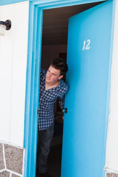 Joven mira fuera de la habitación del motel — Foto de Stock