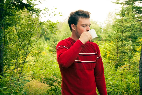 Νεαρός άνδρας στη φύση με μια κούπα του καφέ — Φωτογραφία Αρχείου