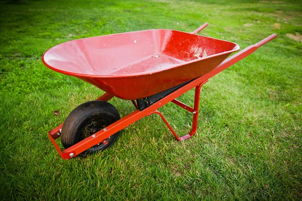 Czerwony wózek na trawniku — Zdjęcie stockowe