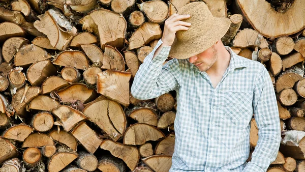 Ung man i en stråhatt på en bakgrund av trä — Stockfoto