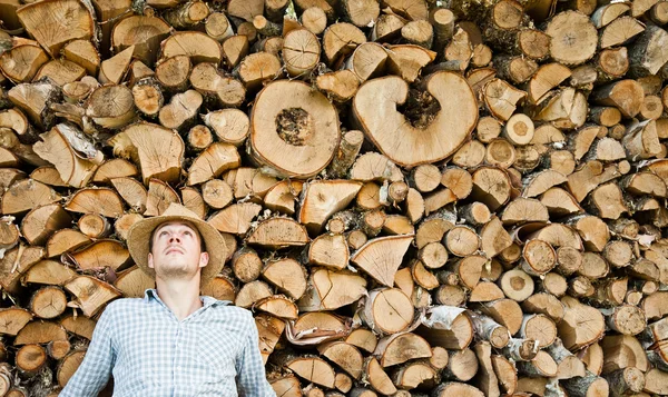 Młody człowiek w słomkowym kapeluszu na tle drewna — Zdjęcie stockowe