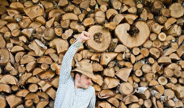 Νεαρός άνδρας σε ένα ψάθινο καπέλο σε φόντο του ξύλου — Φωτογραφία Αρχείου