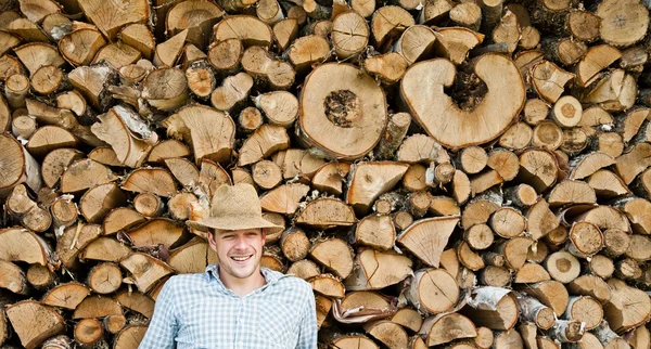 Fiatal férfi-egy szalma kalap a fa háttér — Stock Fotó