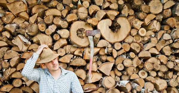 Jeune homme dans un chapeau de paille sur un fond de bois — Photo