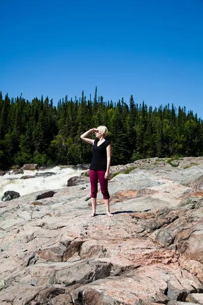 Jente står på en klippe – stockfoto