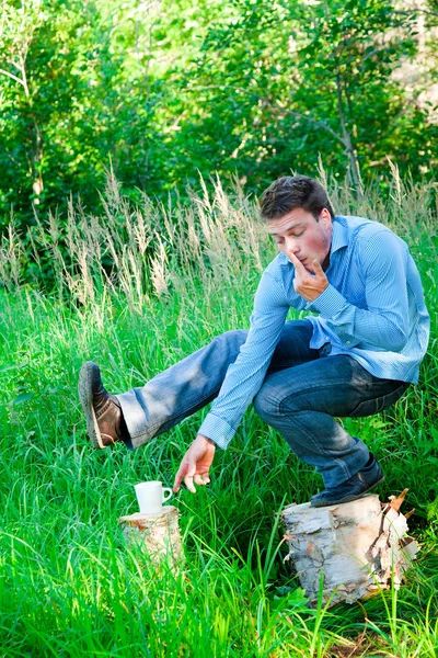 Un joven en la naturaleza con una taza — Foto de Stock