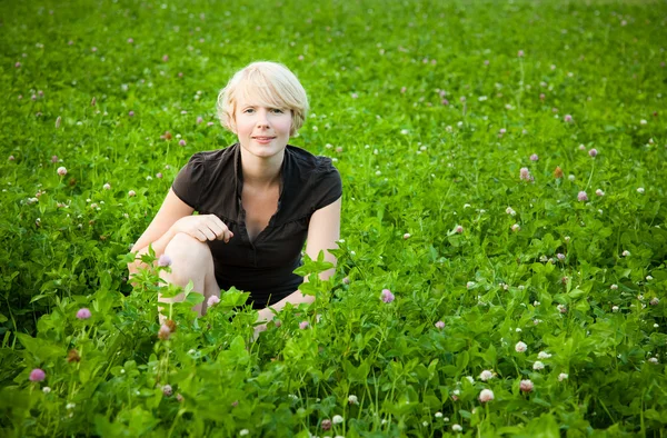 Flicka i ett fält av blommor — Stockfoto