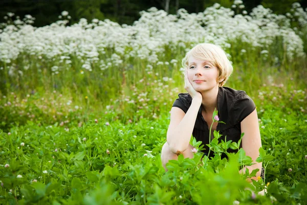 Meisje in een veld van bloemen — Stockfoto