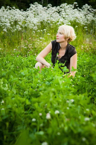 Meisje in een veld van bloemen — Stockfoto