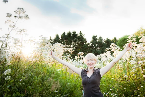 Flicka i ett fält av blommor — Stockfoto