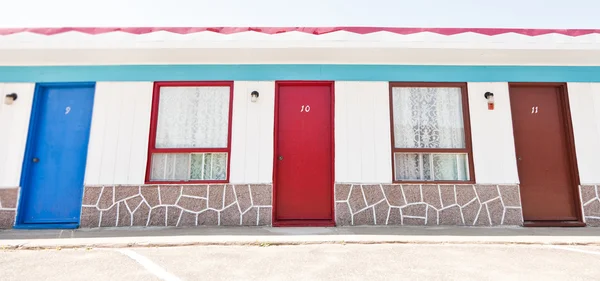 Motell med röda och blå dörrar — Stockfoto