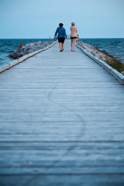Due ragazze che camminano sul molo — Foto Stock