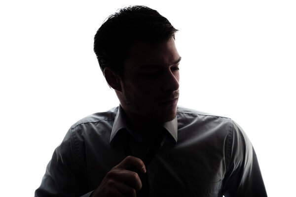 Силуэт бизнесмена немного ослабил галстук после работы
