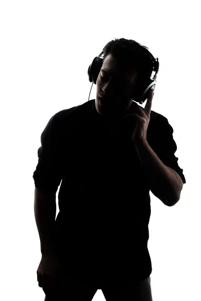 Uomo in silhouette ascoltando le cuffie — Foto Stock