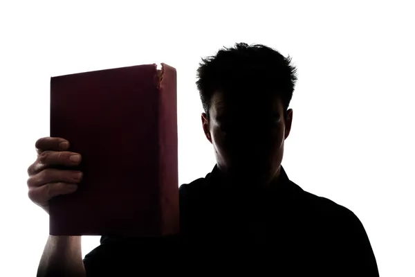 Figura del hombre en silueta mostrando un libro —  Fotos de Stock