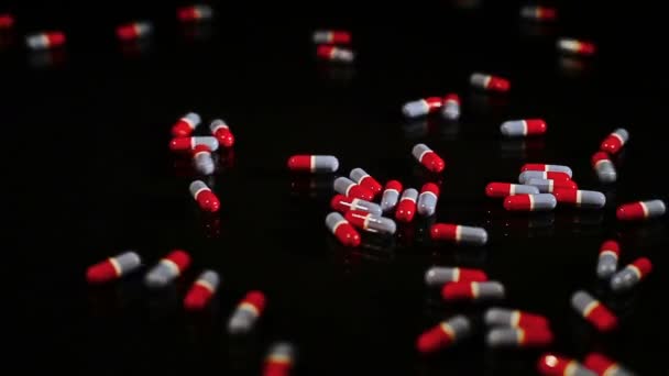 Pilules capsules coulissantes sur verre noir - isolées — Video