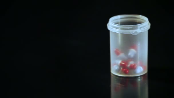Капсулы с таблетками попадают в контейнер — стоковое видео
