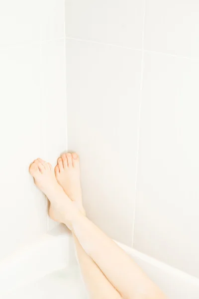 Pernas de mulher no canto do banho — Fotografia de Stock
