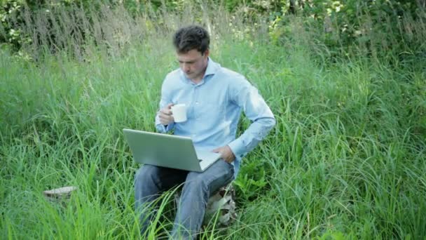 Empresario trabajando al aire libre con una taza de café — Vídeos de Stock