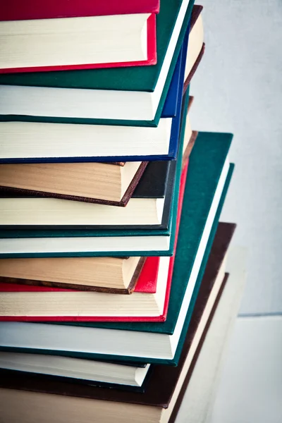 Pilha muito alta de livros em uma mesa — Fotografia de Stock