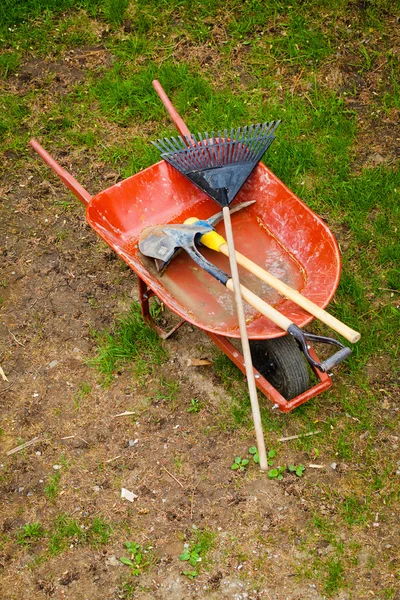 Gamla wheelbarow med trädgårdsredskap — Stockfoto