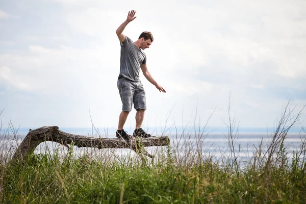 Junge Erwachsene balancieren im Urlaub auf einem Baum — Stockfoto