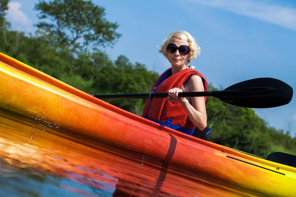 Donna con gilet di sicurezza Kayak da sola su un fiume calmo — Foto Stock
