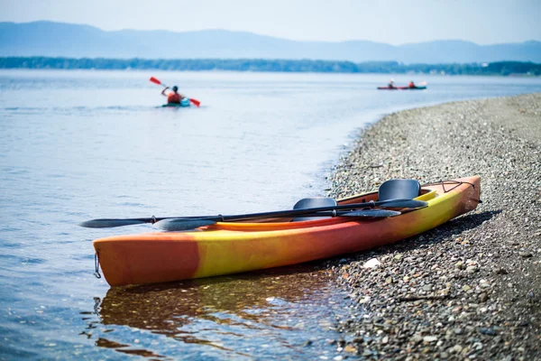 पृष्ठभूमि में Kayakers साथ समुद्र तट पर Kayak — स्टॉक फ़ोटो, इमेज