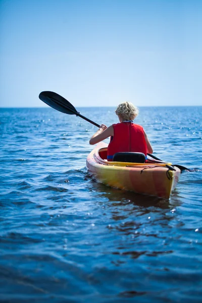Женщина в спасательном жилете отправляется в море одна — стоковое фото