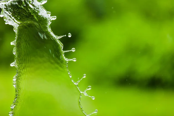 Queda de água respingo sobre fundo abstrato verde com quarto fo — Fotografia de Stock