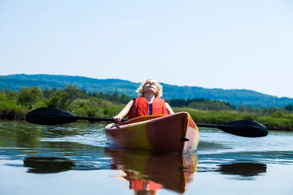 Mujer Relajándose en un kayak y disfrutando de su vida — Foto de Stock