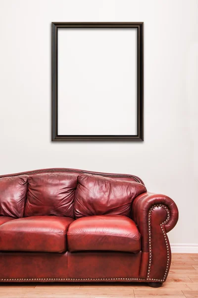Πολυτελές κόκκινο δερμάτινο καναπέ μπροστά από έναν κενό τοίχο — Φωτογραφία Αρχείου