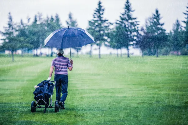 Golfer op een regenachtige dag verlaten de golfbaan — Stockfoto