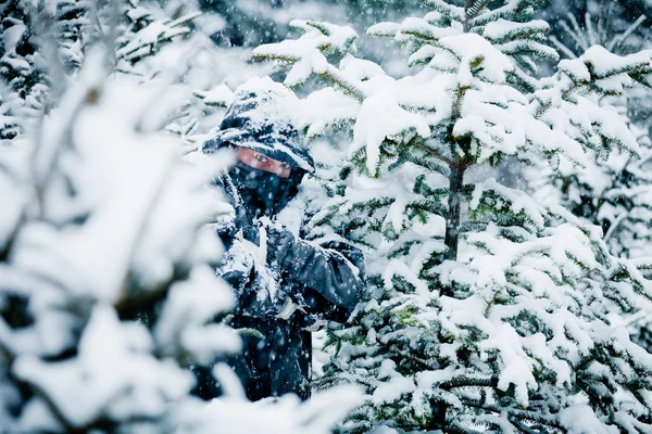 L'homme se cache derrière les arbres dans la forêt — Photo