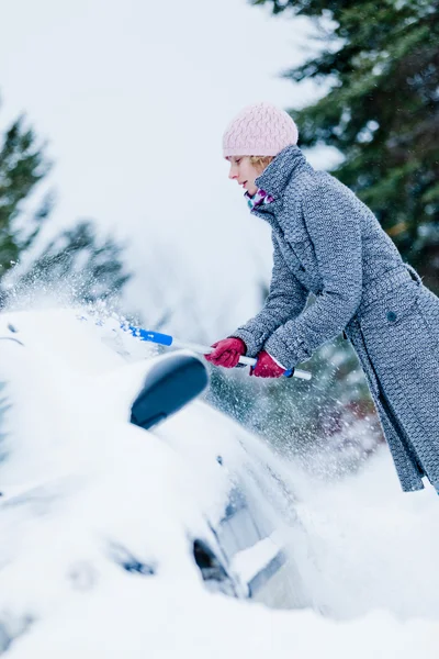 女性、ほうきが付いている車から雪を削除します。 — ストック写真