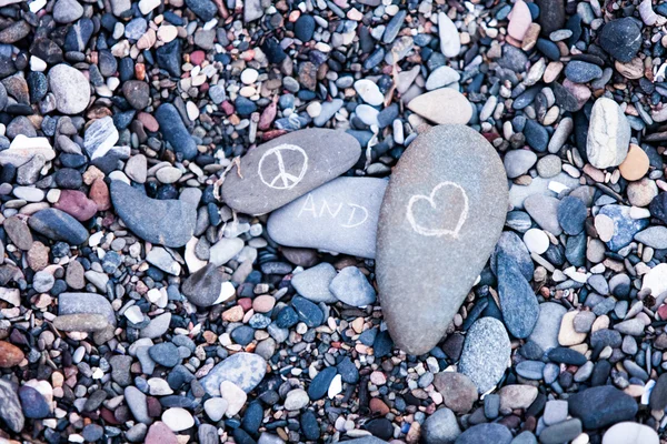 Peace and Love symbols on rocks — Stock Photo, Image