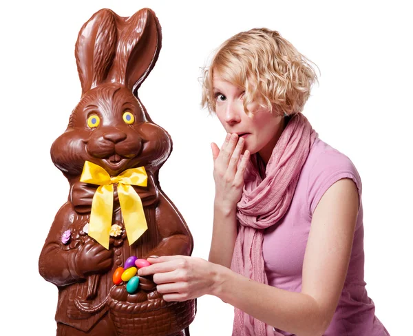 Sarışın kız bir çikolata bunny Paskalya yumurtası çalarken — Stok fotoğraf